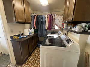 Laundry area featuring washing machine and clothes dryer and cabinet space