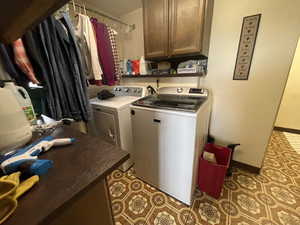 Laundry area with cabinet space, washing machine and dryer, baseboards, and tile patterned floors