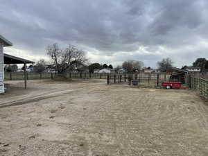 View of yard with a rural view, an outdoor structure, and fence