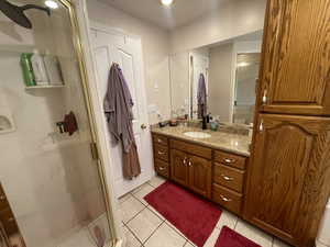 Full bath featuring tile patterned floors, a shower stall, and vanity