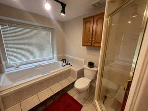 Full bath featuring visible vents, toilet, a stall shower, tile patterned flooring, and a jetted tub