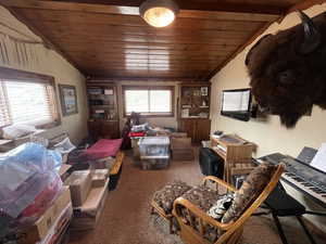 Living room with lofted ceiling, carpet, and wood ceiling