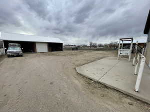 Exterior space with a garage, fence, and an outbuilding