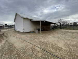 View of property exterior with an outbuilding, metal roof, and an exterior structure