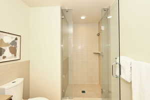 Full bathroom with a stall shower and tile walls