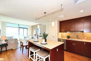 Kitchen with tasteful backsplash, light countertops, open floor plan and dishwasher