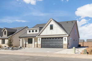 View of front of property with stone siding, central AC, and driveway