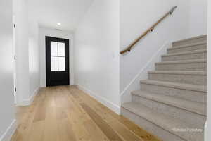 Entryway with stairs, recessed lighting, baseboards, and hardwood / wood-style flooring