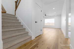 Staircase with wood-type flooring, baseboards, and recessed lighting