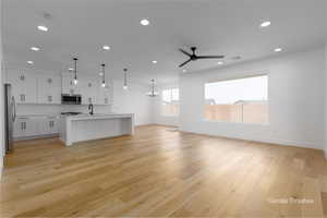 Unfurnished living room with recessed lighting, visible vents, light wood finished floors, and ceiling fan with notable chandelier