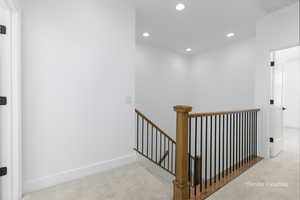 Interior space featuring carpet, visible vents, an upstairs landing, and recessed lighting