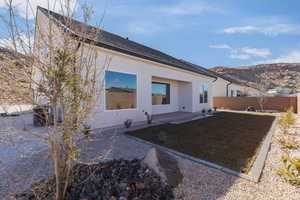 Back of property featuring central AC unit, fence, a patio area, a mountain view, and stucco siding