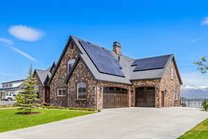 View of front of home with an attached garage, fence, concrete driveway, a chimney, and a front yard