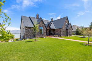 View of front of house with a chimney, a mountain view, and a front yard