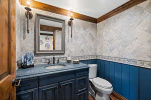 Bathroom featuring crown molding, vanity, and toilet