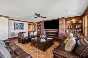 Living area with ceiling fan, built in shelves, recessed lighting, a fireplace, and light wood finished floors