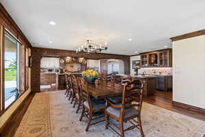 Dining space featuring arched walkways, ornamental molding, wood finished floors, and a notable chandelier