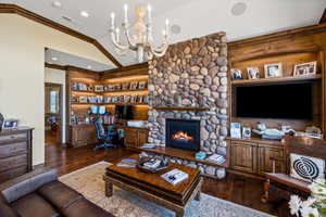 Living area featuring built in desk, dark wood finished floors, visible vents, and crown molding