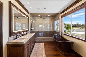 Bathroom featuring a freestanding bath, wood finished floors, a sink, and a shower stall