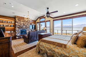 Bedroom featuring dark wood-style floors, a fireplace, visible vents, vaulted ceiling, and access to outside