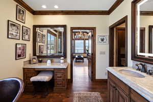 Bathroom featuring baseboards, ornamental molding, hardwood / wood-style floors, vanity, and recessed lighting