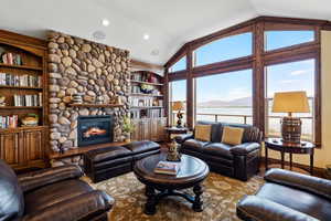 Living area featuring lofted ceiling, built in shelves, a fireplace, and recessed lighting