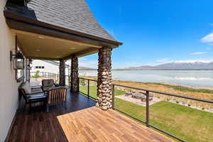 Deck featuring an outdoor fire pit, a lawn, and a water and mountain view