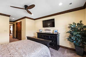 Bedroom with ornamental molding, carpet, visible vents, and baseboards