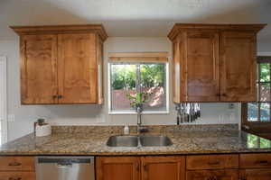 Kitchen featuring stone countertops, knotty alder cabinets