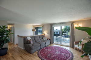 Living room with hardwood floors and views off the balcony.