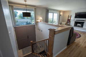 Foyer entrance featuring light hardwood flooring and a tiled fireplace