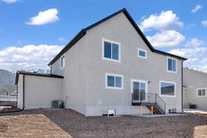 Back of house featuring central air condition unit and stucco siding