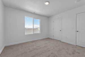 Unfurnished bedroom with baseboards, a textured ceiling, visible vents, and carpet flooring