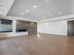 Unfurnished living room with recessed lighting, visible vents, a fireplace, and wood finished floors