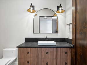 Bathroom featuring toilet, visible vents, and vanity