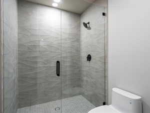 Bathroom with a shower stall and toilet