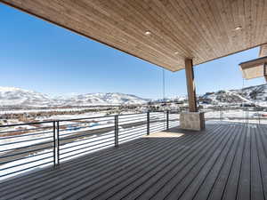 Snow covered deck featuring a mountain view