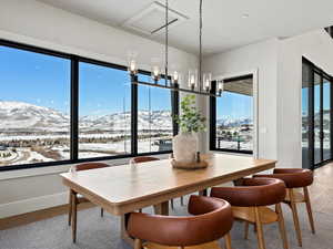 Dining room featuring baseboards, a mountain view, and light wood-style floors