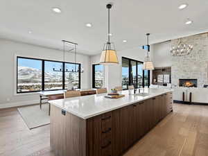 Kitchen featuring light wood finished floors, a large island, modern cabinets, and a sink