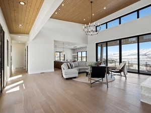 Living room with baseboards, wooden ceiling, light wood-style floors, a chandelier, and a mountain view