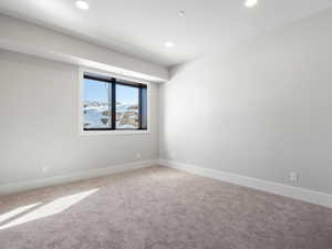 Carpeted spare room with recessed lighting and baseboards