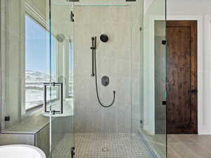 Full bathroom featuring a wealth of natural light, a stall shower, and a bathing tub