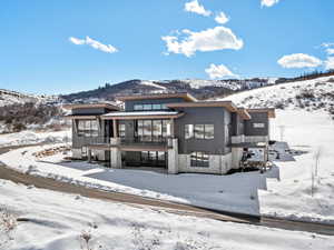 Exterior space with stone siding, a mountain view, and a balcony