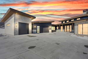 Contemporary home with stone siding, an attached garage, and concrete driveway