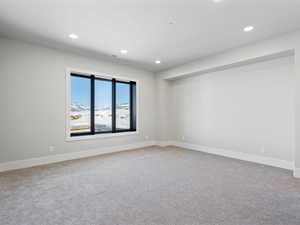 Carpeted spare room with baseboards, visible vents, and recessed lighting