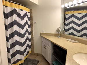 Full bath with a shower with shower curtain, tile patterned flooring, and vanity