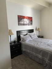 Bedroom featuring vaulted ceiling with beams and carpet