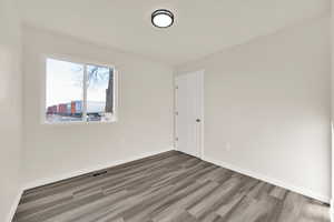 Bedroom featuring textured ceilings, baseboards, and wood finished floors