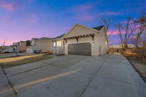 View of front of home with concrete driveway, stucco siding, an attached 2 car garage