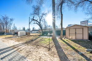 View of yard featuring a shed, fence, and an patio